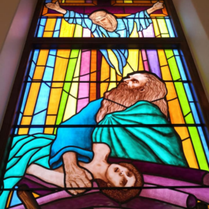painted stained glass windows depicting Isaac offering Jacob