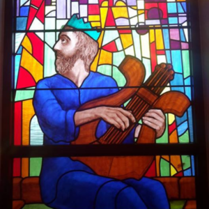 Painted stained glass window depicting king david playing his harp